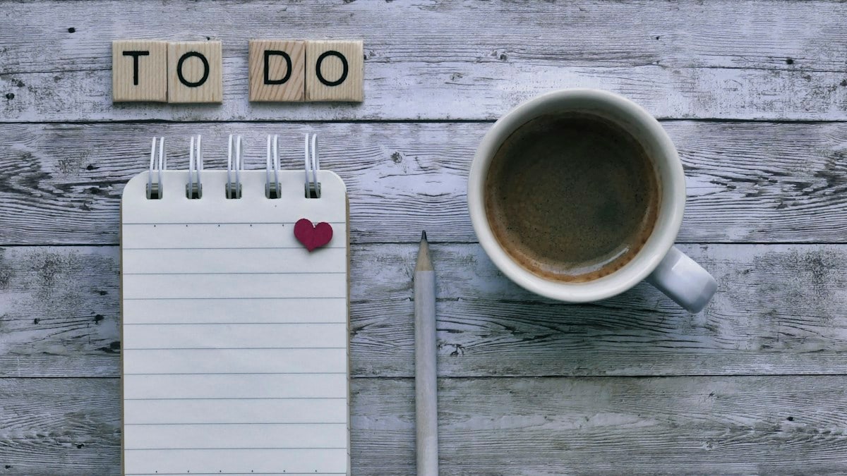 To do list, coffee, and pencil on wooden background